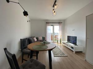 a living room with a table and a tv at Apartament Nad Stawem in Wadowice