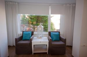 a living room with two chairs and a table and a window at Pension Oranje in Zandvoort