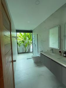 a bathroom with a sink and a toilet and a window at LAILA Villas in Koh Samui 