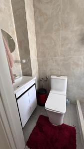 a bathroom with a white toilet and a sink at Harmony Lake House in Chon-Sary-Oy +40 photos