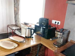 a kitchen counter with a coffee maker and a microwave at La Casa de Forja in Tarilonte