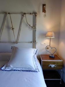 a bed with a white pillow and a lamp on a night stand at La Casa de Forja in Tarilonte