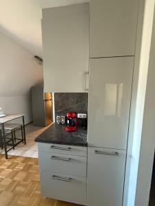 a kitchen with white cabinets and a red appliance at Old town comfort and cozy apartment 2 in Dachau