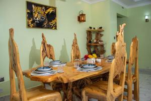 a dining room with a wooden table and chairs at Sereni Rooftop Villa in Nanyuki