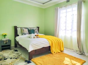 纳纽基Sereni Rooftop Villa的卧室里有一张床，床上铺着一条黄色的毯子