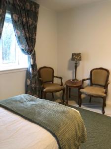 a bedroom with two chairs and a bed and a window at Landvetter Airport B&B and Parking in Härryda