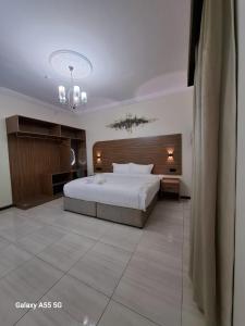 a bedroom with a large white bed and a chandelier at بست تريب ميلانو للشقق المخدومة in Jeddah +41 photos
