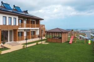 a yard with a playground and a house at Pensiunea EVIA CORBU in Corbu