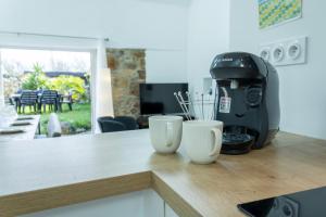a kitchen counter with a coffee maker and two white cups at Ty Eol - WiFi - Authentique in Camaret-sur-Mer