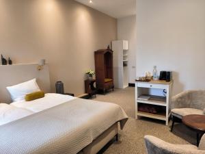 a bedroom with a bed and a table and a chair at Mariafarm in Zevenbergen