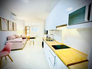 a kitchen and living room with a couch and a table at Apartamentos Guerrero in Merida