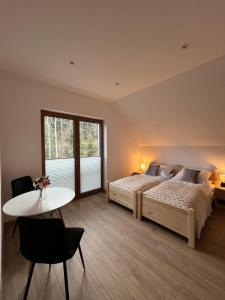 a bedroom with a bed and a table and a desk at Malowany Las in Międzybrodzie Bialskie