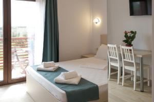 a bedroom with a bed and a table and chairs at Pensiunea EVIA CORBU in Corbu