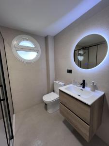 a bathroom with a toilet and a sink and a mirror at Villa de Béjar 2 in Béjar +15 photos