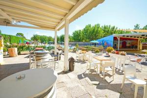 a patio with tables and chairs on a patio at Mobile Home Emma in Lido di Dante