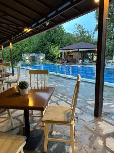 a patio with a table and chairs and a pool at Archontiko Liamas in Stavros