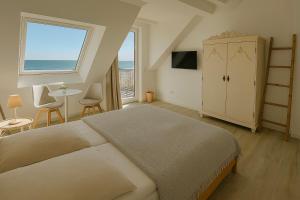 a bedroom with a bed and a table and a window at Lodge am Meer in Glücksburg