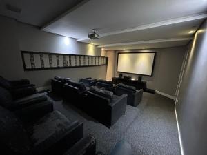 a cinema room with couches and a screen at Apartamento 207 varias piscinas in Bombinhas +29 photos