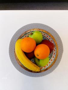 eine Schale Obst mit Äpfeln Orangen und Bananen in der Unterkunft LuxApart Dzidzikovac City Centar free parking in Sarajevo