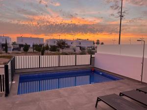 a swimming pool with a sunset in the background at Casa Posterus, villa met prive zwembad in Dolores