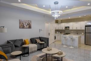 a living room with a couch and tables and a kitchen at The view apartment 1 in Al Baha