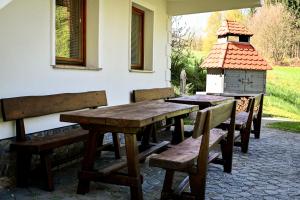 a wooden table and benches on a patio at Countryside house, 1,5 hour from Bled in Male Brusnice