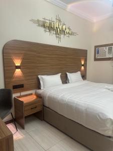 a bedroom with a large bed and a chandelier at نسيم الفجر للشقق المخدومة in Jeddah