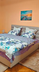 a bed in a bedroom with a painting on the wall at CozyRent Ocna Mures in Ocna-Mureşului