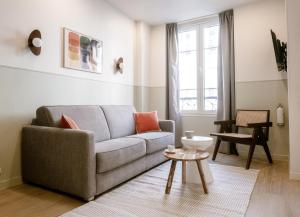 ein Wohnzimmer mit Couch und Tisch in der Unterkunft Babylon Popincourt in Paris + 110 Fotos