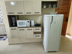 a kitchen with a white refrigerator and a microwave at Casa Vista da Pedra in Domingos Martins +43 photos