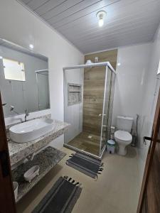 a bathroom with a shower and a sink and a toilet at Casa Vista da Pedra in Domingos Martins