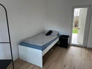 a small bed in a room with a door at 3-Zimmer Ferienunterkunft in Bad Salzuflen