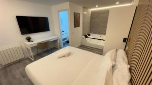 马德里JACUZZI ROOMS Atocha的白色的客房配有白色的床和电视。