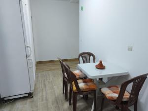 una sala da pranzo con tavolo, sedie e frigorifero di DarSalam a Martil