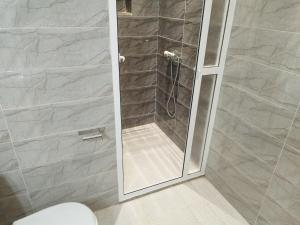 una doccia con una porta in vetro in un bagno di DarSalam a Martil