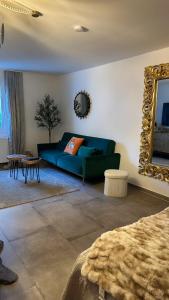 a living room with a green couch and a mirror at Stilvolles Apartment nähe Messe Düsseldorf in Duisburg Süd in Duisburg