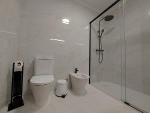 een witte badkamer met toilet en douche bij Beach & Surf in Ribeira Grande +21 foto's