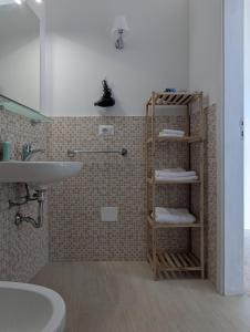a bathroom with a toilet and a sink and a shelf at Dimora Matteotti in Nardò +28 photos