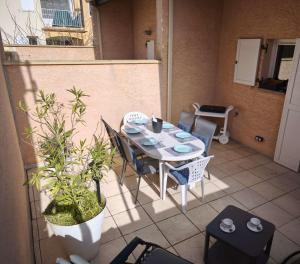 a table and chairs sitting on a patio with a table and chairsktop at Charmant pavillon pour 5-6 pers. in Cap d'Agde +14 photos