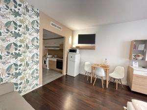 kuchnia i salon ze stołem i krzesłami w obiekcie Bike & Spa Velence Apartman w mieście Velence