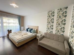 sypialnia z dużym łóżkiem i kanapą w obiekcie Bike & Spa Velence Apartman w mieście Velence