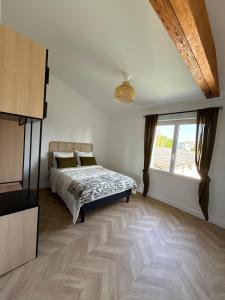 a bedroom with a bed and a large window at Appartement cosy et élégant in Ambarès-et-Lagrave +1 photo