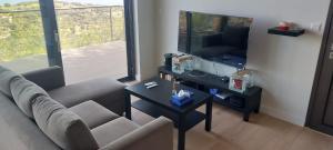 a living room with a couch and a tv and a table at Philip's Akamas Retreat in Neo Chorio