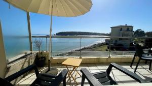 - Balcón con sillas, mesa y sombrilla en Ty Jean - Piscine - plage à pied, en Crozon