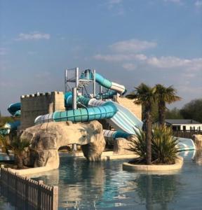 a water slide in front of a water park at Mobil home 4 à 6 pers camping 5 étoiles proche Deauville in Saint-Arnoult