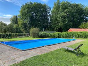 a swimming pool in a yard with a chair at Ferienhaus in Hechthausen in Hechthausen