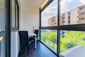 Una habitación con una mesa y sillas y una ventana grande. en Flex SelfCheckIns 147 - Zagreb - Bedroom - Garage - Loggia, en Zagreb