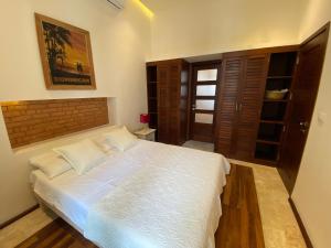 a bedroom with a large bed with white sheets at Boutique Hotel Casa Grande, Tropical Journey, Suite familiar de 2 dormitorios in Santo Domingo
