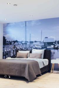 a bedroom with a large bed in front of a marina at Appartement Aan de Veste in Enkhuizen