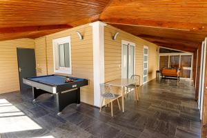 Un porche cubierto con una mesa de billar y una mesa de ping pong. en La Villa Vétiver, en Saint-Joseph